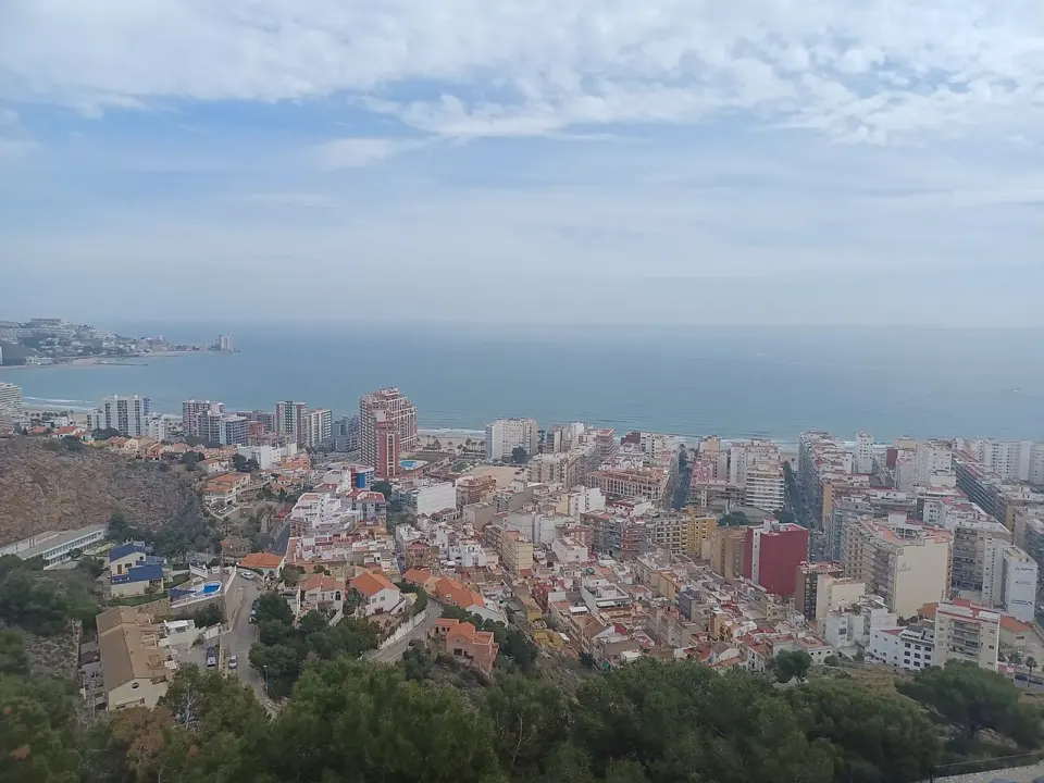 Vista de Cullera desde el castillo, con los edificios de la ciudad, la bahía y el mar Mediterráneo al fondo