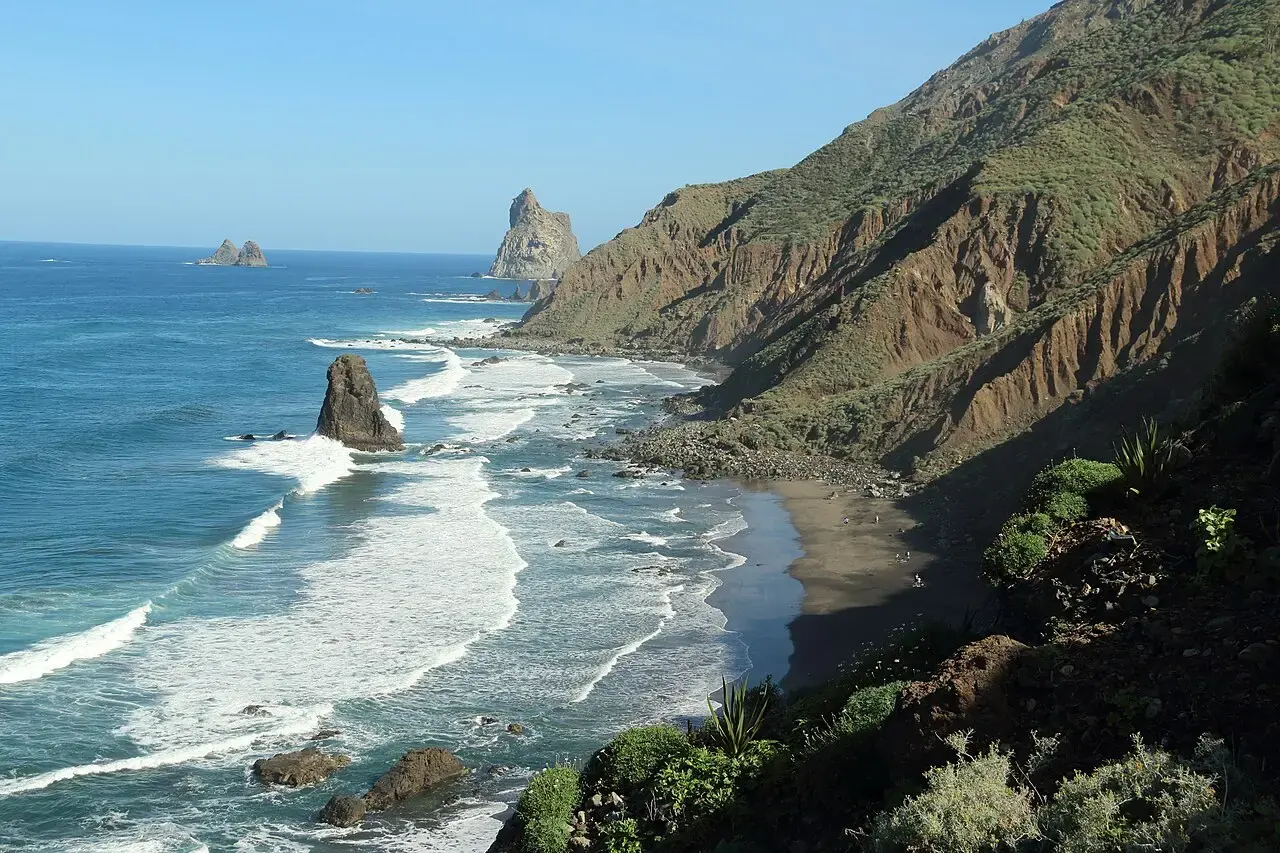 Playa de Benijo con oleaje, roques en el mar y laderas verdes y escarpadas del macizo de Anaga