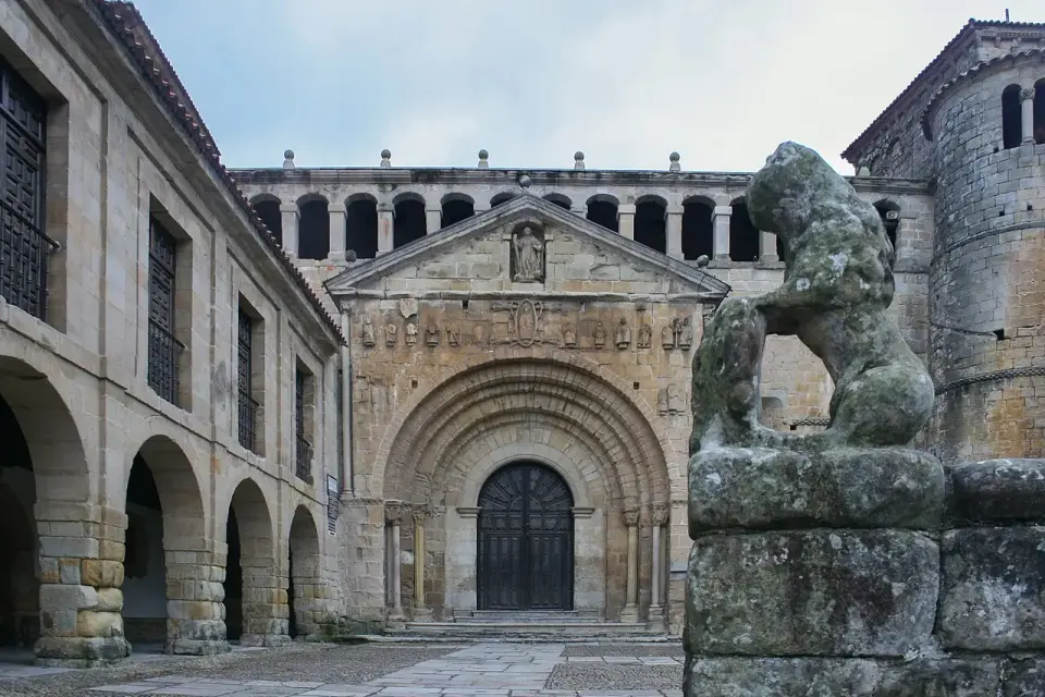 Portada románica de la colegiata de Santa Juliana en Santillana del Mar, con un león de piedra en primer plano