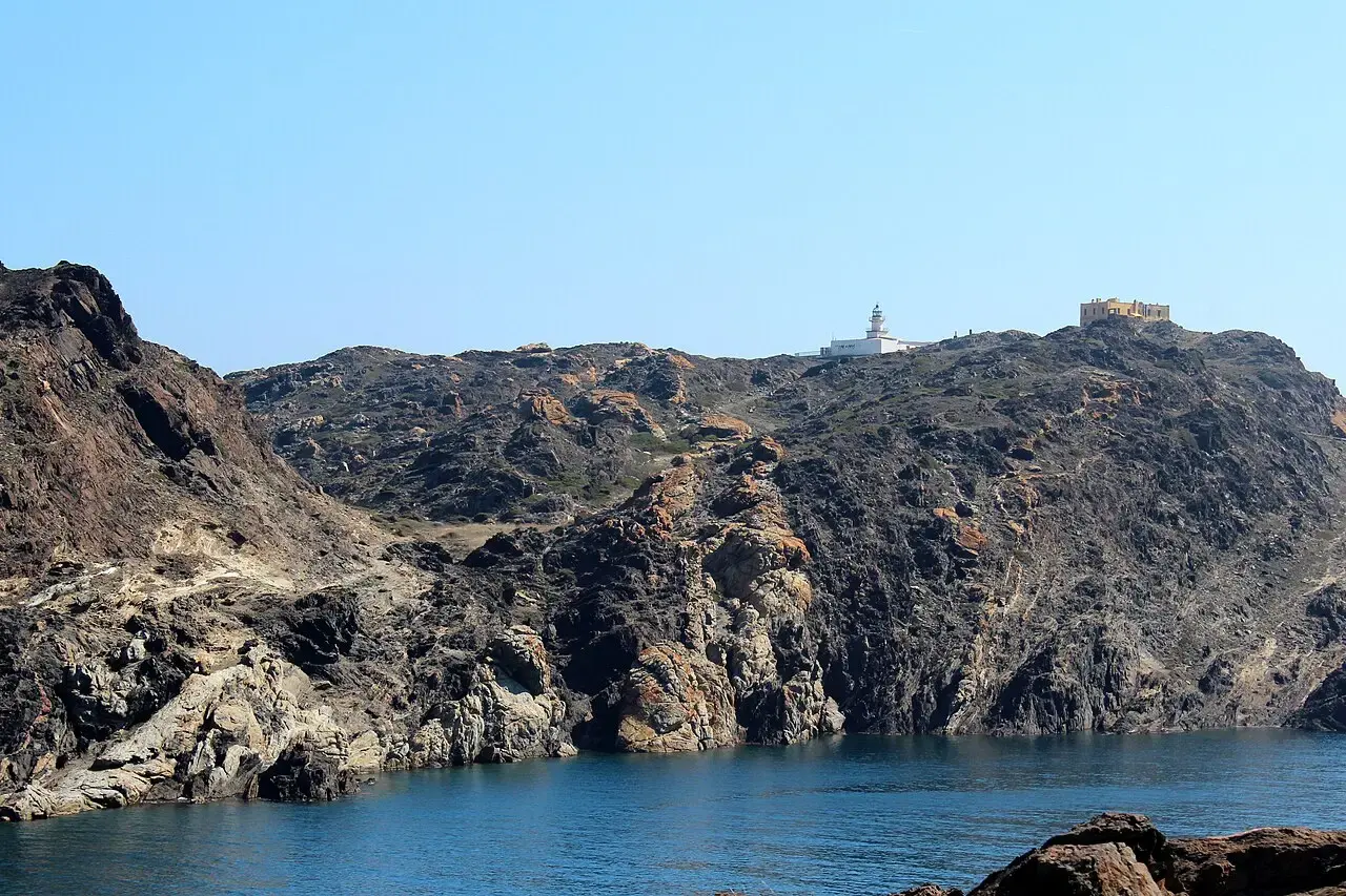 El faro del Cap de Creus en lo alto de un promontorio de roca oscura sobre el mar