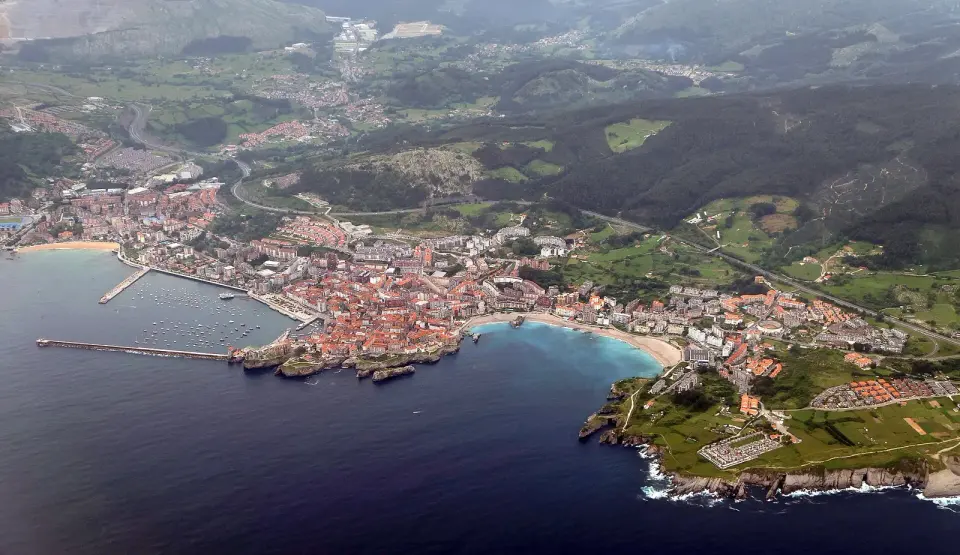 Vista aérea de Castro Urdiales, con el puerto, la iglesia gótica junto al mar y los montes verdes detrás