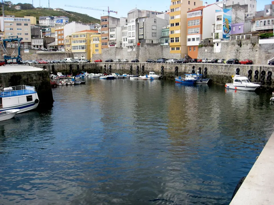 Dársena del puerto de Malpica con barcas amarradas y edificios de colores frente al agua
