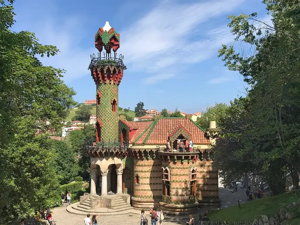 El Capricho de Gaudí en Comillas, con su torre cubierta de cerámica verde y fachada de ladrillo rodeada de árboles