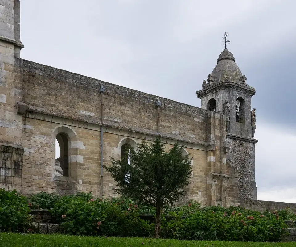 Muro lateral de piedra del santuario de Urkiola y su pequeño campanario
