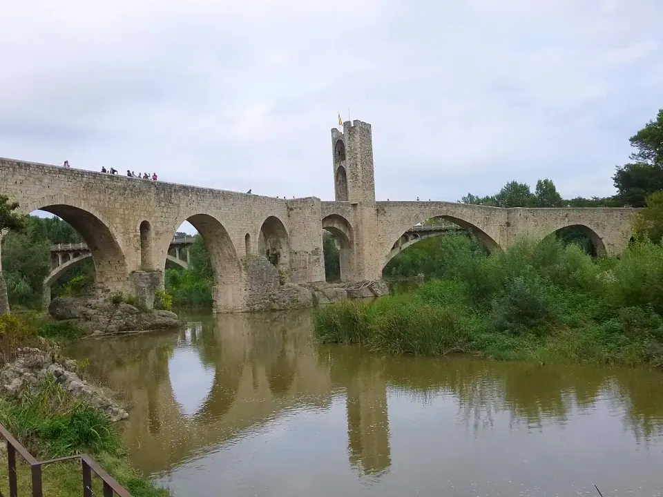 Puente medieval de Besalú con su torre de defensa, reflejado en el río Fluvià