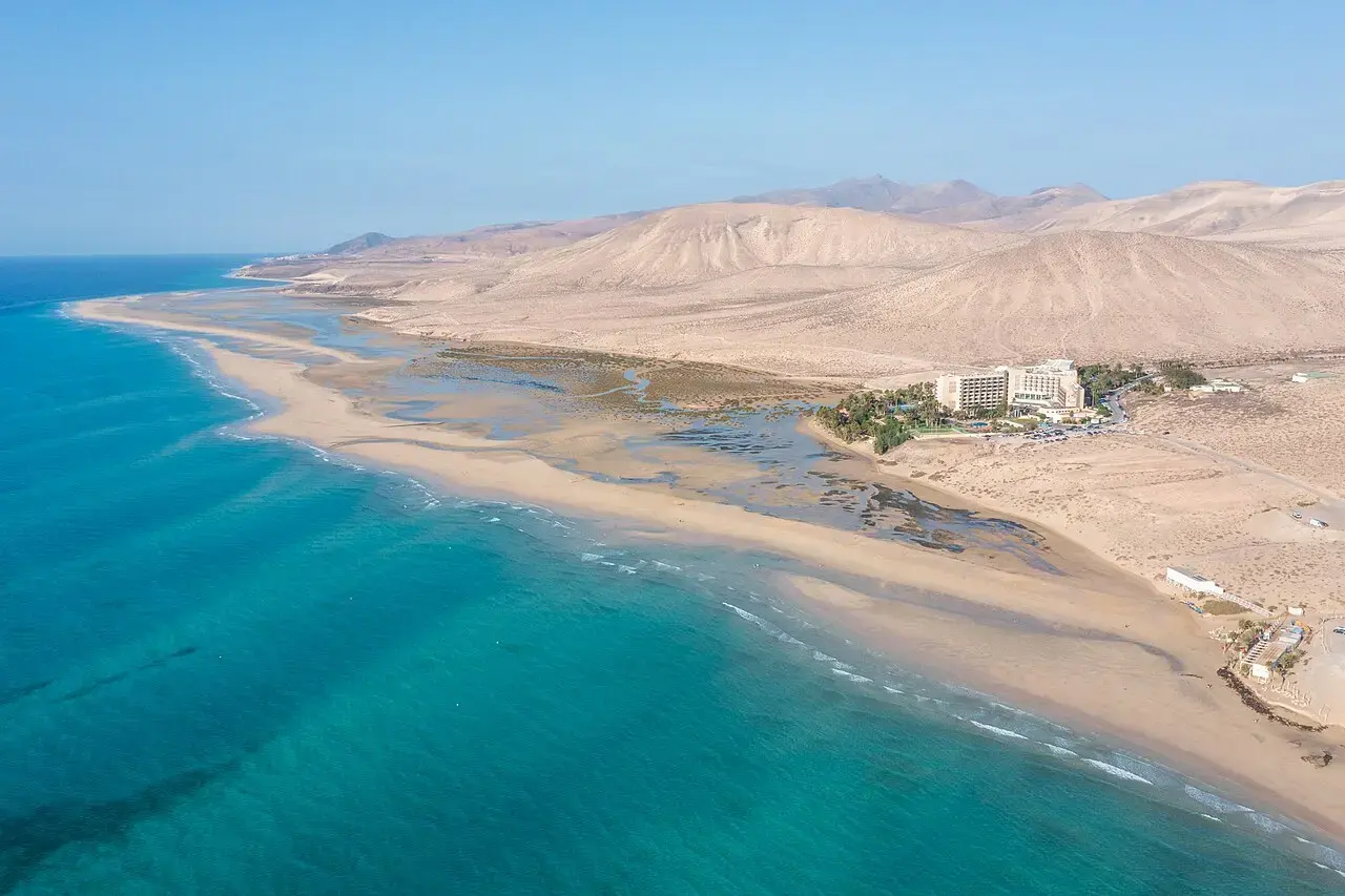 Vista aérea de la playa de Sotavento, con su laguna de agua turquesa y las montañas de Jandía al fondo