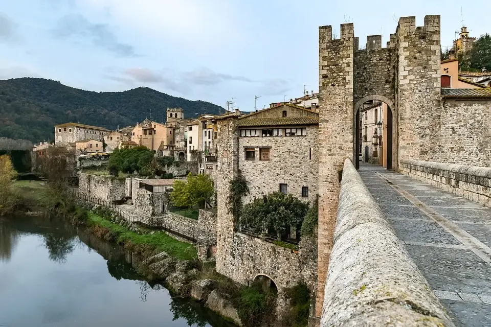 Puente medieval fortificado de Besalú sobre el río Fluvià, con su torre de entrada y el pueblo detrás