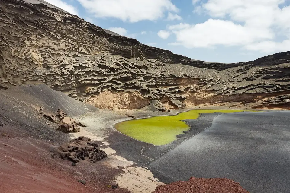 Laguna verde del Charco de los Clicos junto a la playa de arena negra de El Golfo, bajo el cráter