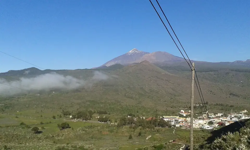 El Teide con nieve en la cumbre y el pueblo de Santiago del Teide en el valle, vistos desde la TF-436