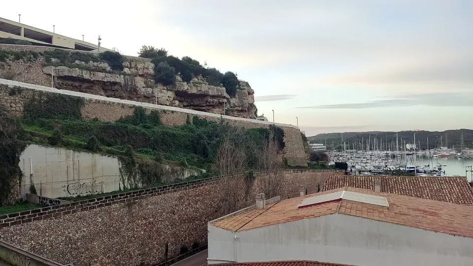Puerto de Maó con barcos al fondo, visto desde la ladera con muros de piedra