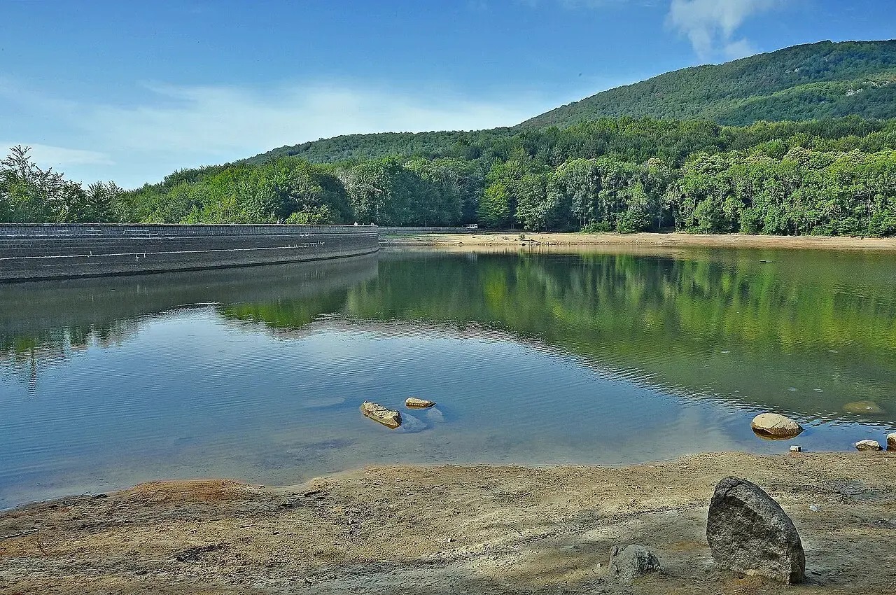 Pantano de Santa Fe del Montseny con aguas tranquilas que reflejan el bosque y las laderas
