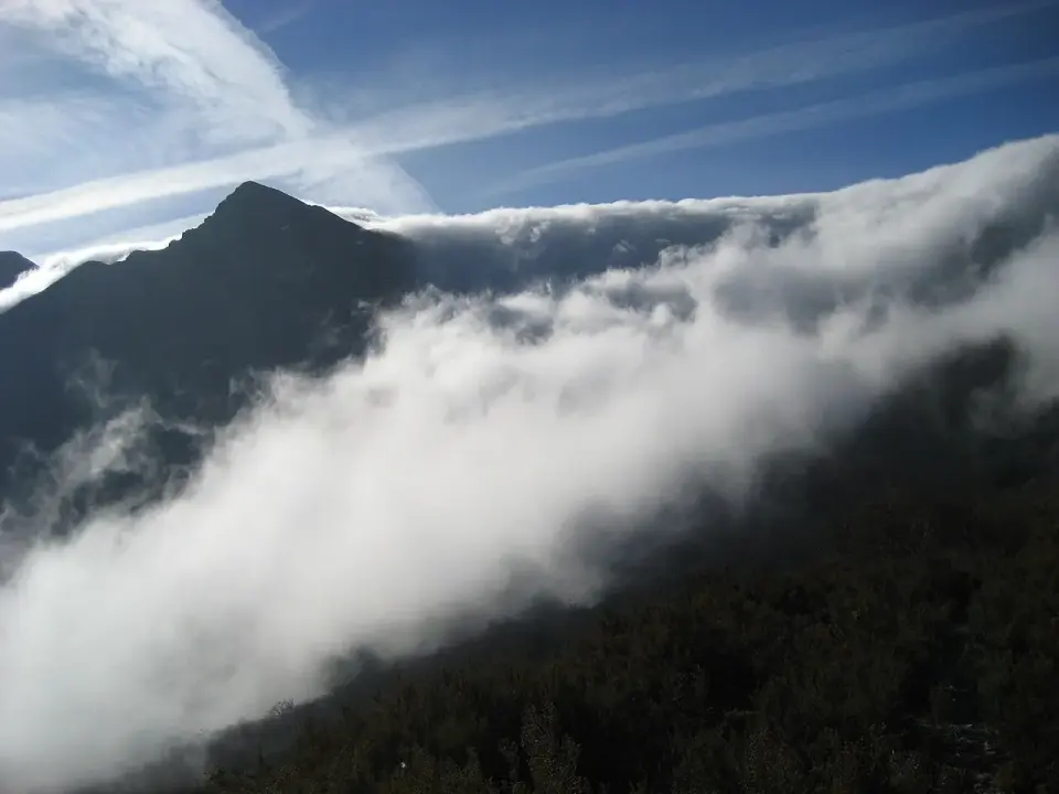 Mar de nubes cubriendo los valles bajo una cumbre oscura, visto desde el puerto de Ancares