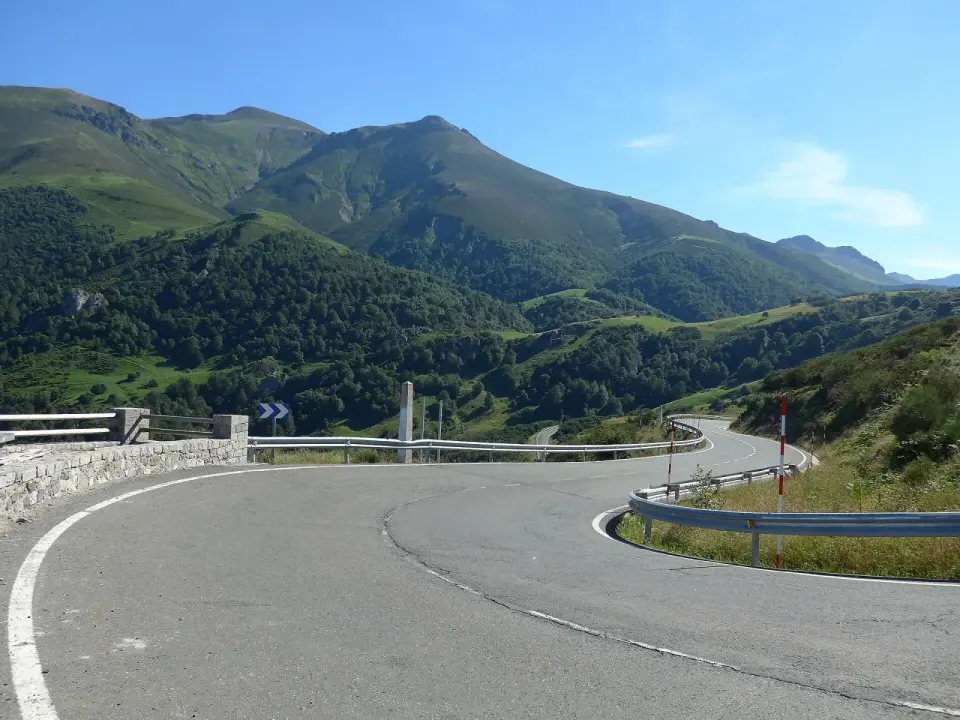 Curva de la carretera N-621 en la subida al puerto de San Glorio, entre prados y montañas de la Cordillera Cantábrica