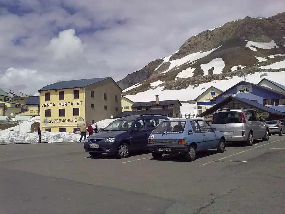 Antiguo puesto fronterizo del Portalet con la Venta Portalet y coches aparcados, rodeado de montañas con nieve