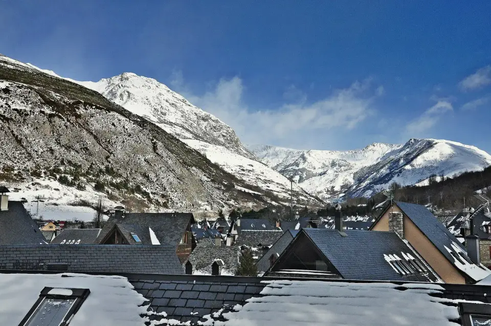 Tejados de pizarra de Arties con montañas nevadas del Val d'Aran al fondo