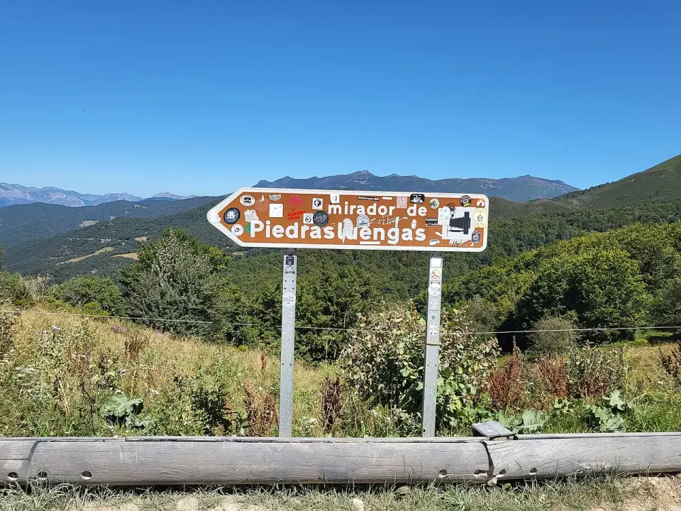 Cartel que indica el mirador de Piedrasluengas junto a la carretera, con montañas al fondo