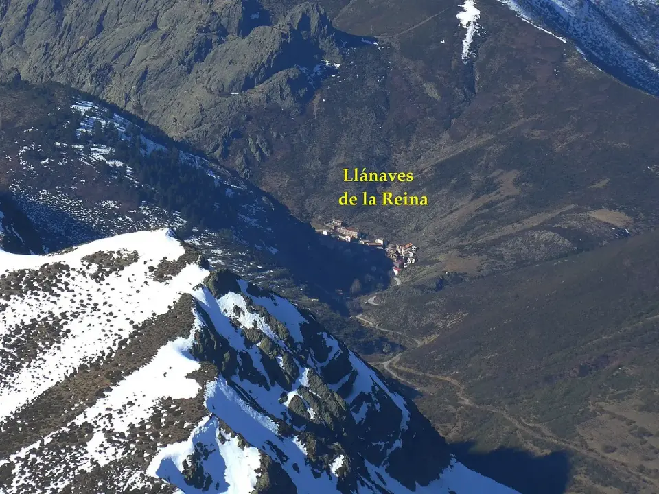 Vista aérea del valle de Llánaves de la Reina con cumbres nevadas en primer plano
