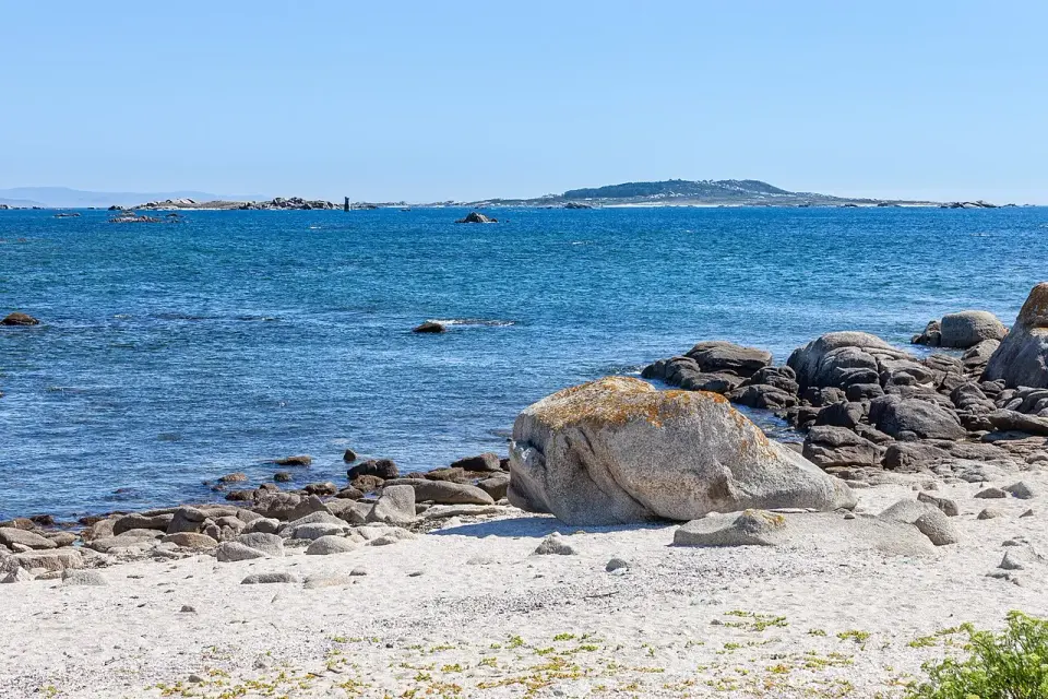 Playa de arena y rocas de granito en Aguiño, con la ría de Arousa y sus islas al fondo