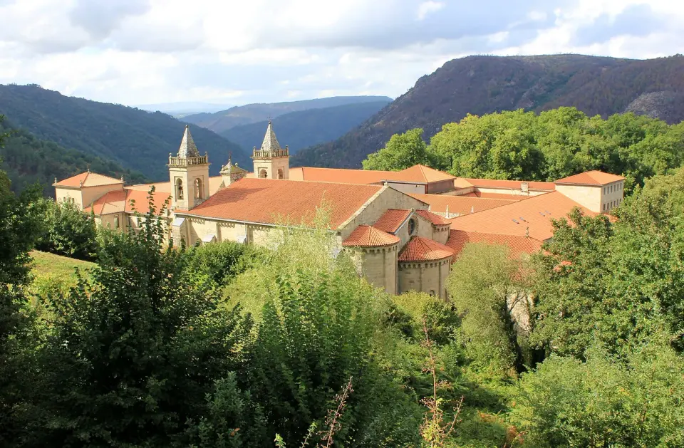Monasterio de Santo Estevo de Ribas de Sil con sus torres y tejados rojos entre bosques sobre el cañón