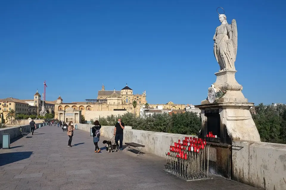 El puente romano de Córdoba con la estatua de San Rafael en primer plano y la Mezquita-catedral al fondo