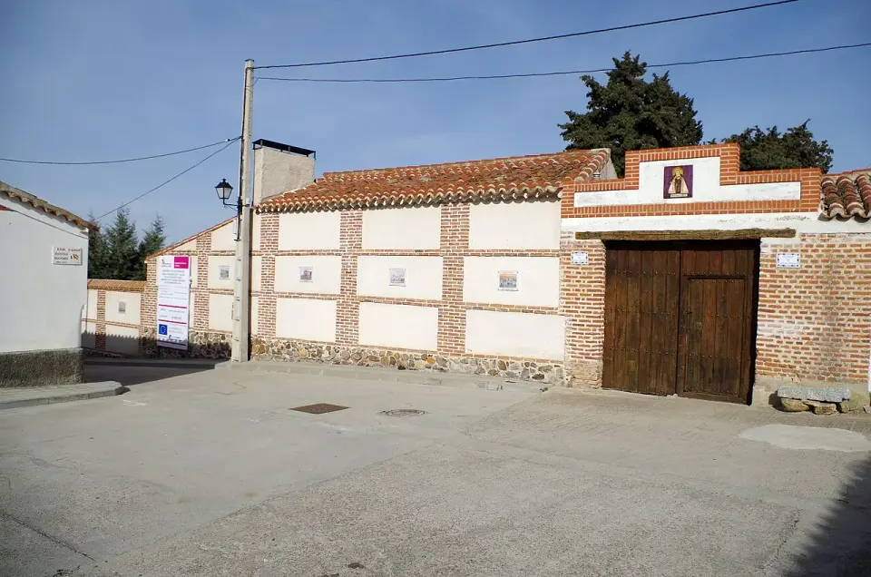 Portón de madera del palomar de Santa Teresa en Gotarrendura, en una tapia de ladrillo y cal con un azulejo de la santa
