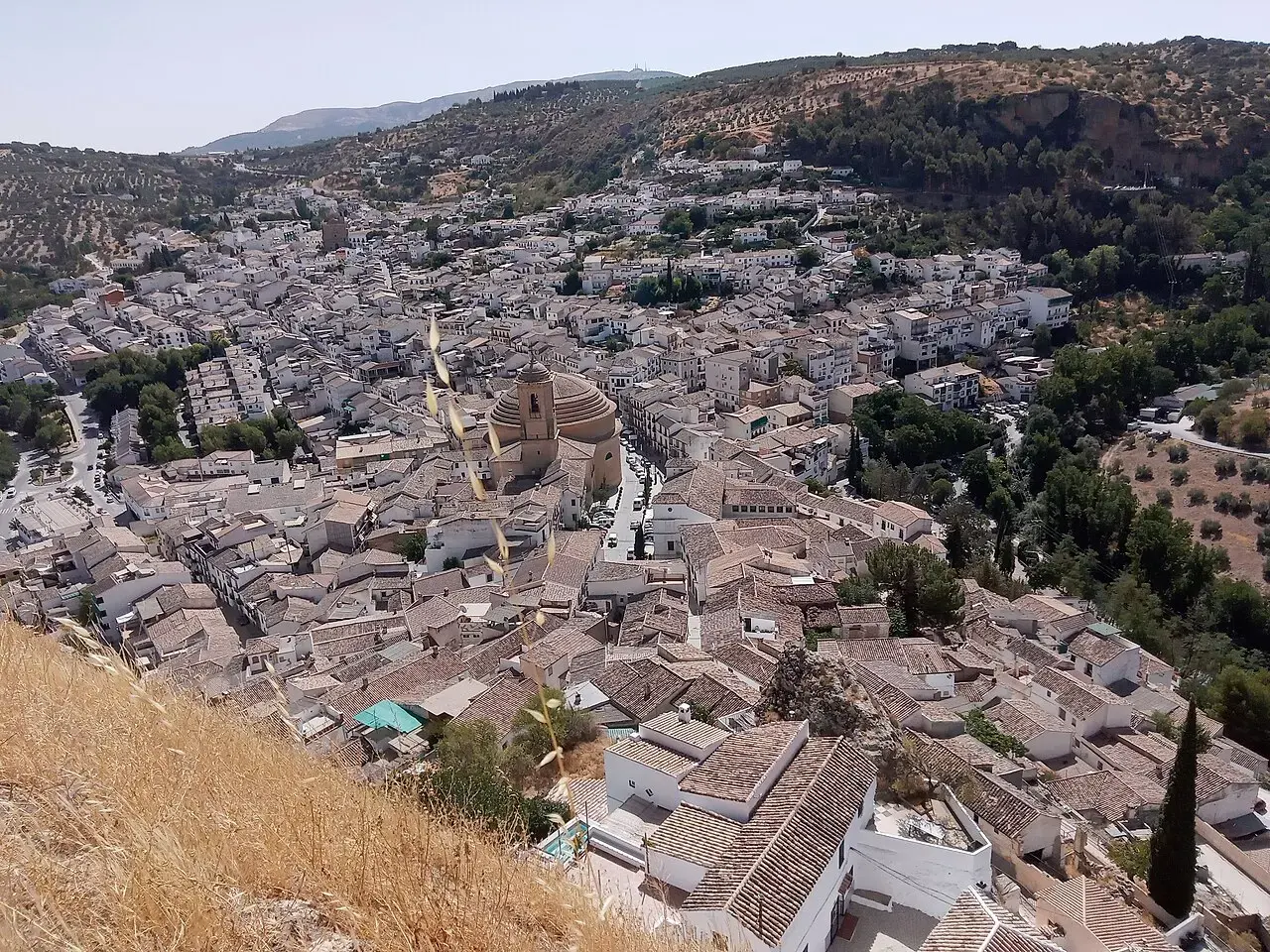 Vista aérea de Montefrío, con su caserío blanco escalonado en la ladera y los olivares y cerros de la comarca al fondo