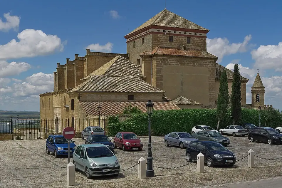 Cabecera de piedra de la Colegiata de Osuna, de líneas renacentistas sobrias, con coches aparcados delante
