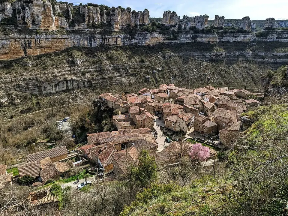 Orbaneja del Castillo vista desde lo alto, con sus tejados rojos en el fondo del cañón del Ebro y paredes de roca caliza