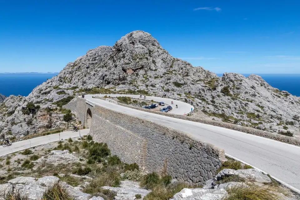 Puente de piedra del Nus de sa Corbata en la carretera de Sa Calobra, con la montaña y el mar detrás