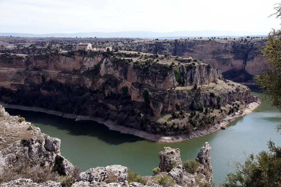 Meandro del Duratón encajado entre cortados de caliza con la ermita de San Frutos en lo alto del cañón