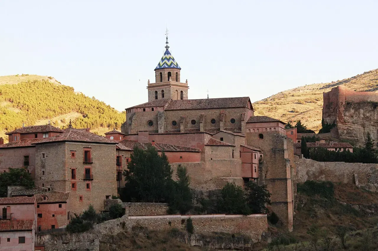 Catedral de Albarracín con su torre de tejas vidriadas, casas de color rojizo y la muralla subiendo por la ladera
