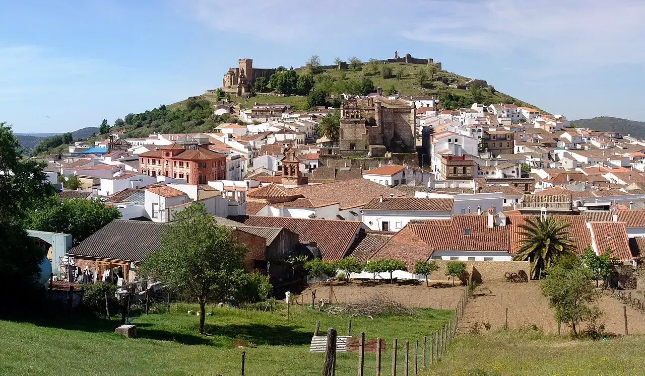Aracena vista desde el campo, con casas blancas al pie del cerro del castillo y la iglesia en lo alto