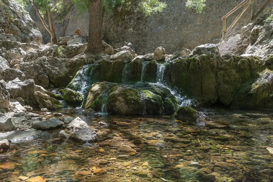 Pequeña cascada sobre rocas cubiertas de musgo en el nacimiento del río Guadalquivir