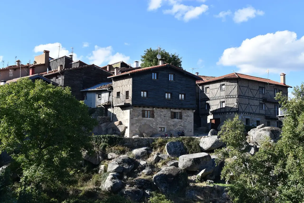 Casas serranas de piedra y entramado de madera de La Alberca asomadas sobre grandes rocas de granito y vegetación