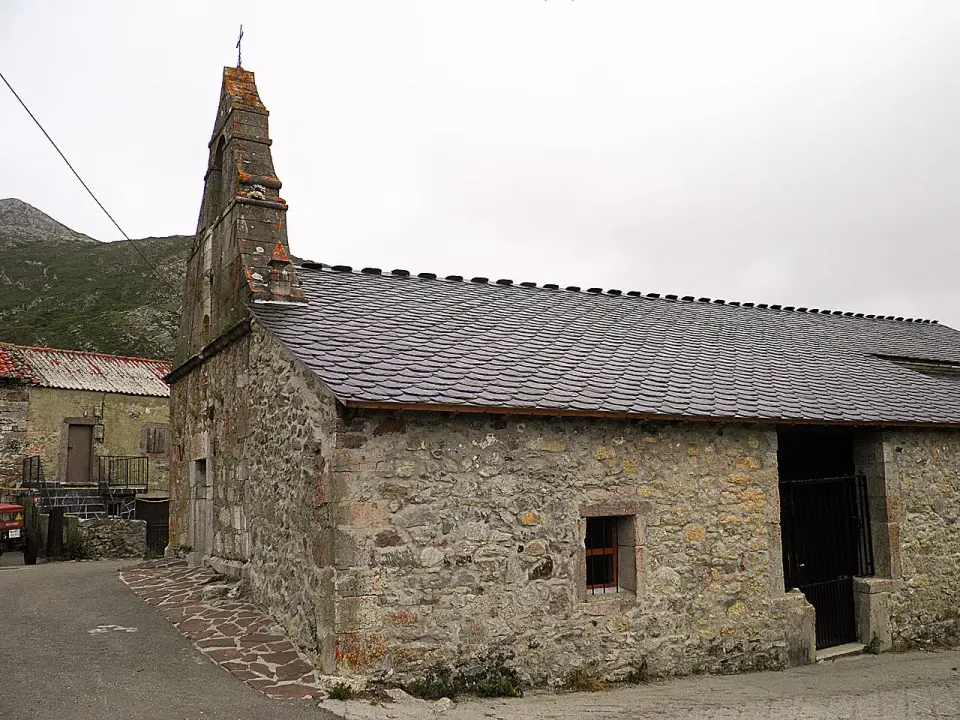Iglesia de piedra con espadaña y tejado de pizarra en Santa María del Puerto, el último pueblo antes del puerto de Somiedo