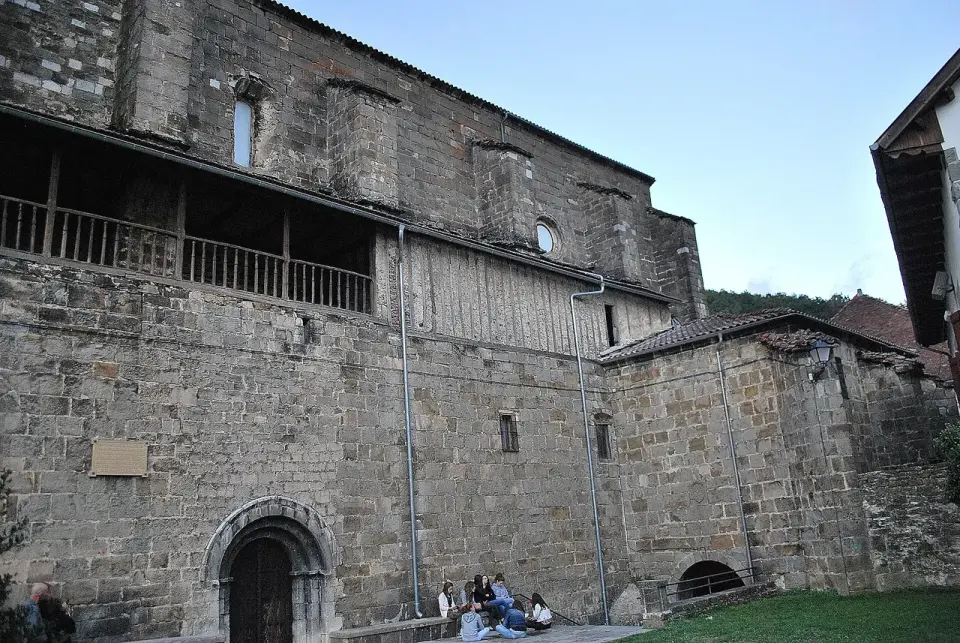 Fachada de piedra de la iglesia de Isaba con su portada de arco y una galería de madera