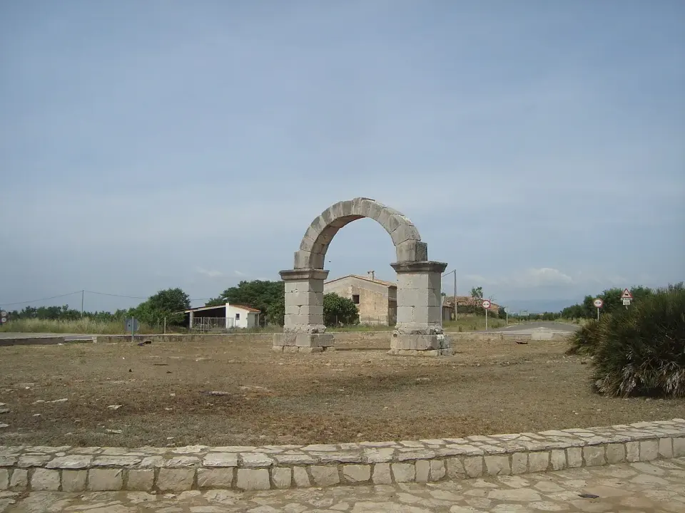 Arco romano de Cabanes, un arco de piedra de un solo vano en medio de una llanura de tierra y matorral