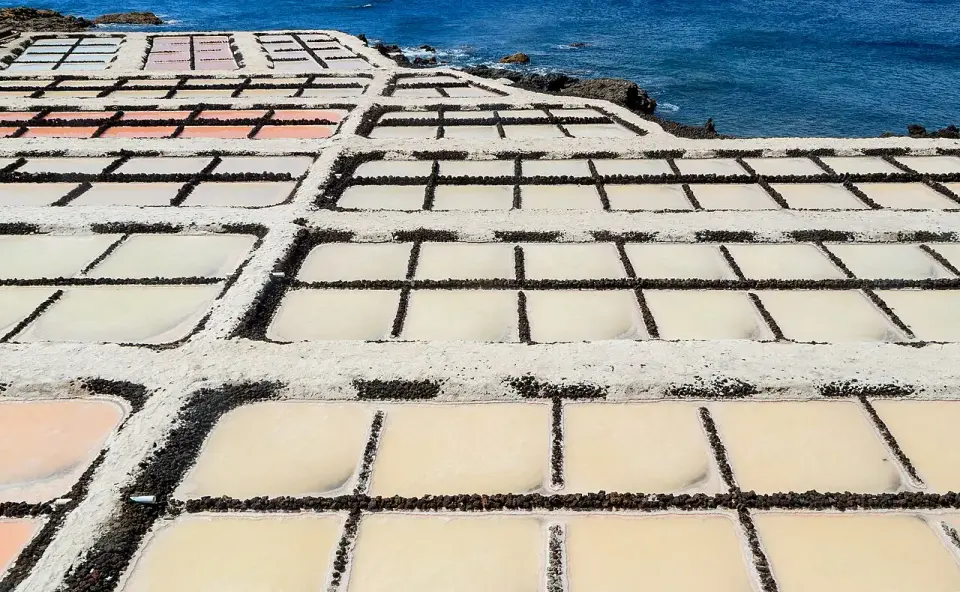 Estanques de las salinas de Fuencaliente con sal blanca y agua rosada junto al mar