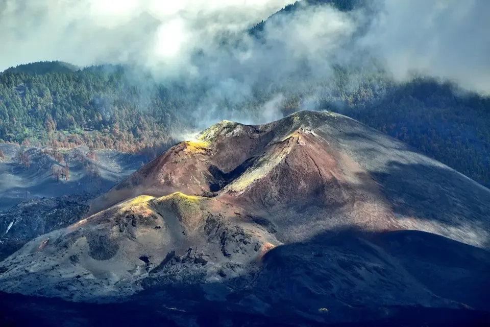 Cono del volcán Tajogaite con laderas de ceniza y lava oscura y nubes de vapor alrededor